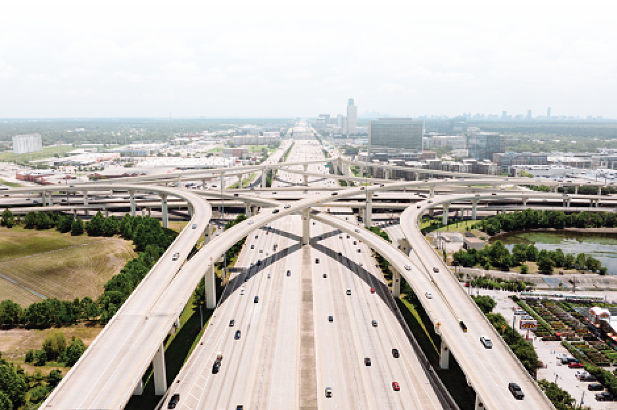 Drone point of view of traffic on the interstate, intertwining on ramps and off ramps.