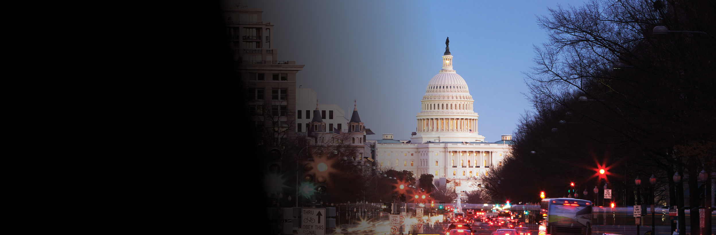 US Capitol building illuminated at night with Pennsylvania Avenue in foreground